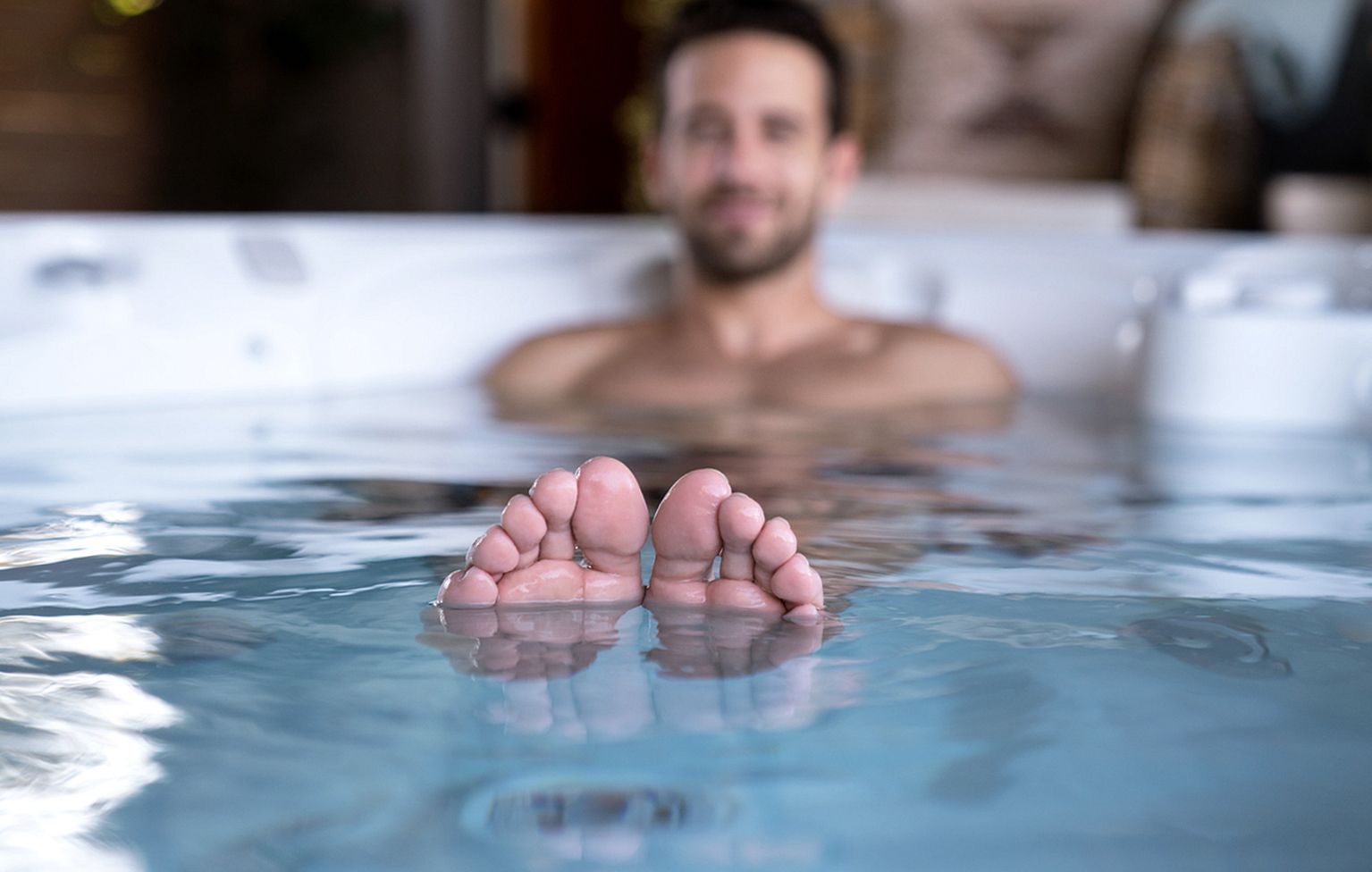 Mann entspannt im warmen Wasser eines Whirlpools